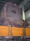 The front rests on wooden blocks and the rear on a combination of wooden blocks and a large steel beam.